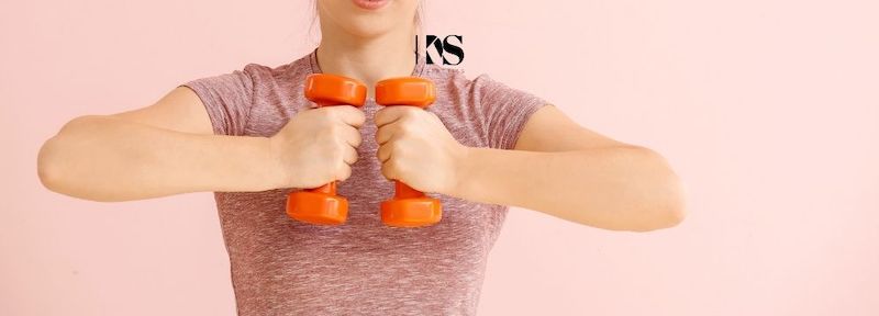 Women exercises her chest and biceps to make the most of the arm lift from Dr. Karen Szymanski